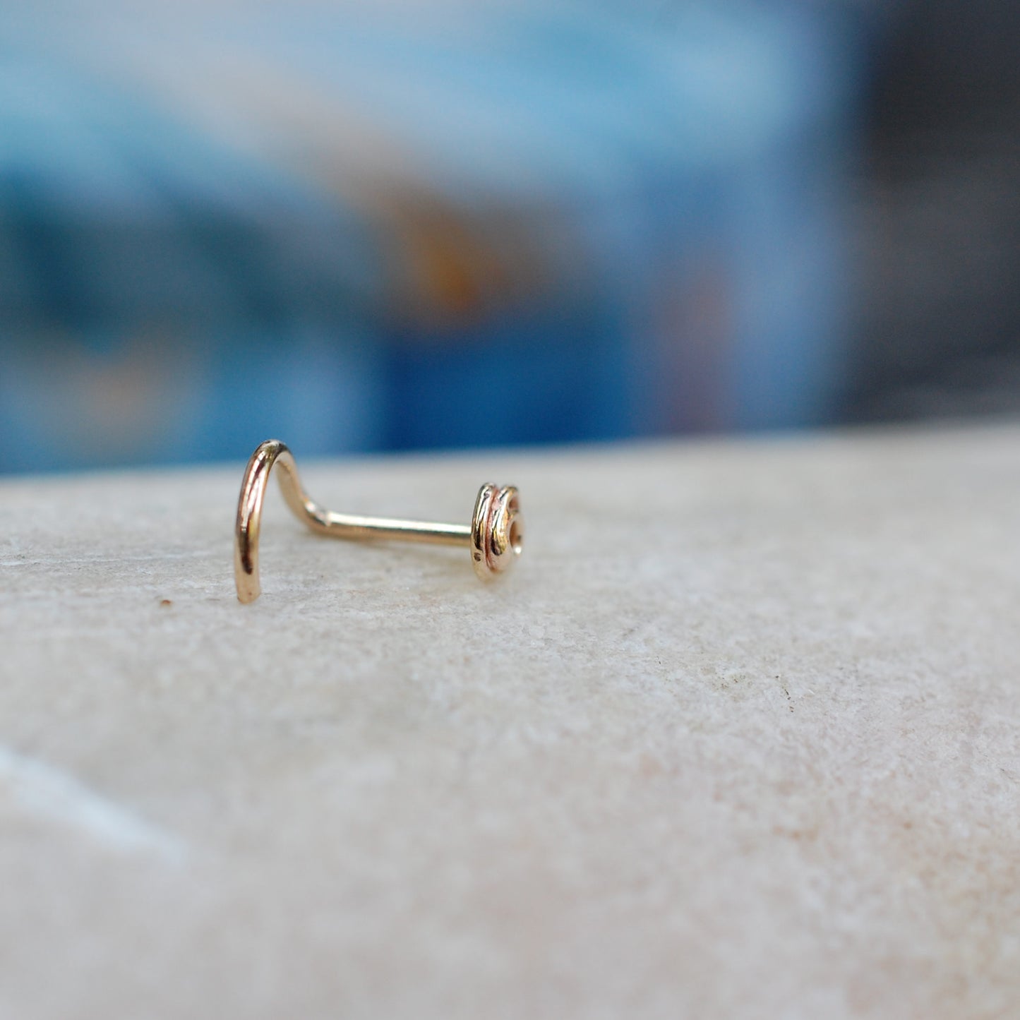 side view of gold scribble nose stud