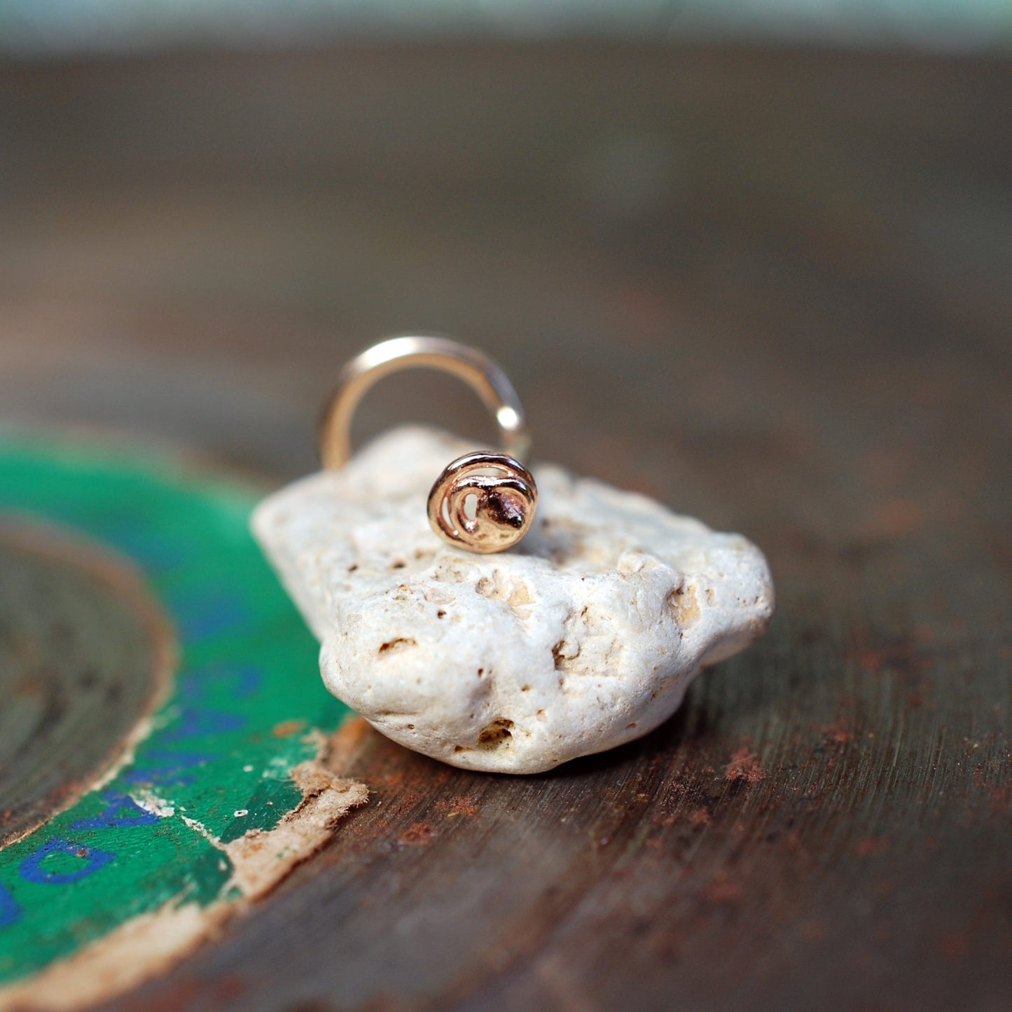 tiny gold nose stud in a scribble freeform pattern