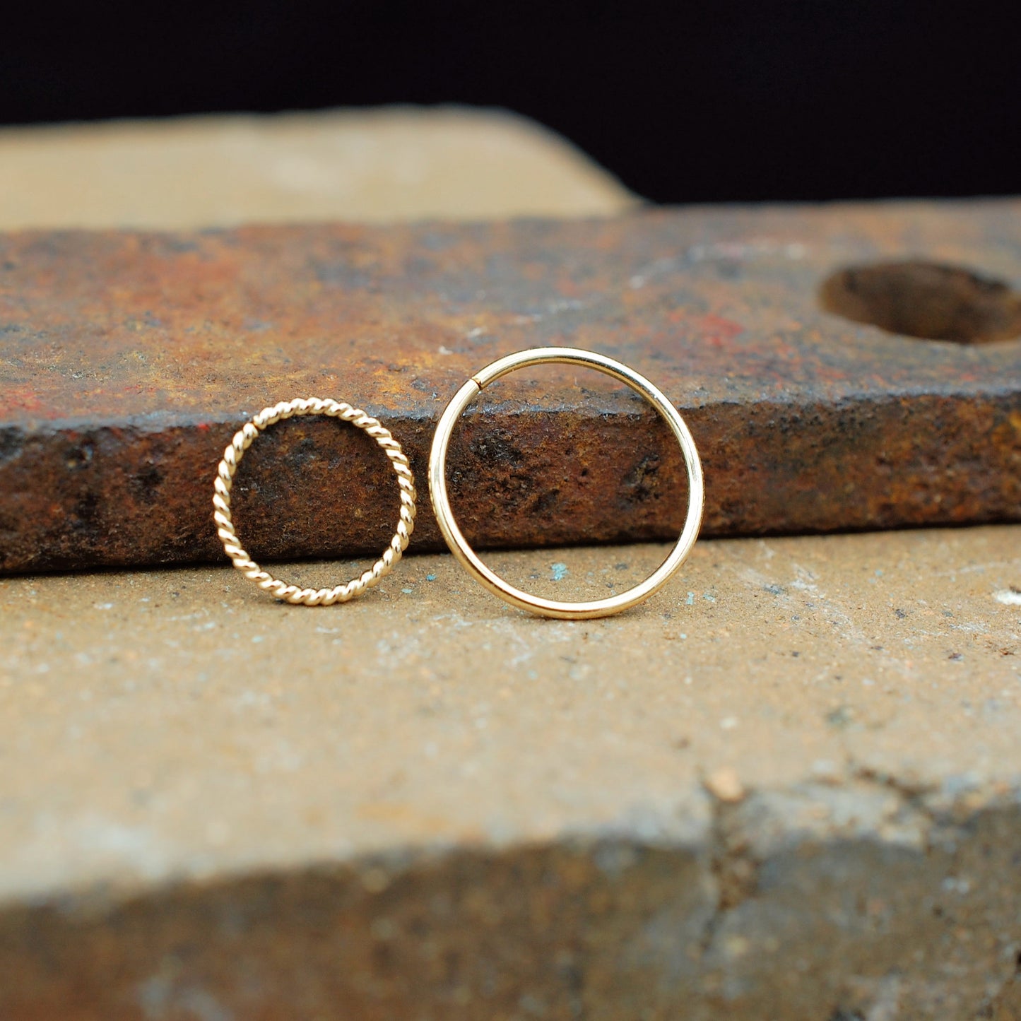 pair of nose rings one is twisted and one is sleek in gold