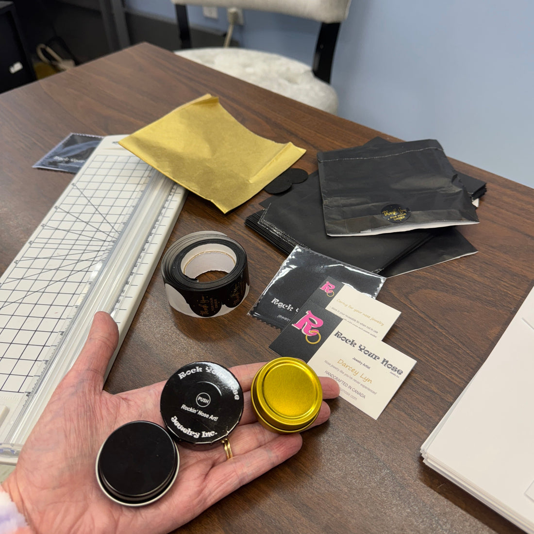 tiny metal tins shown on a hand 