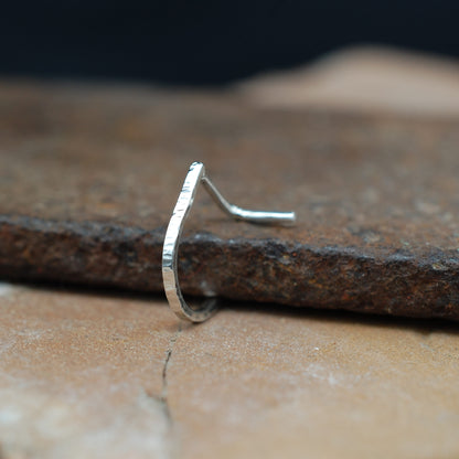 Silver nose ring on a textured stone surface