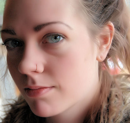 gold twisted nose ring on a model
