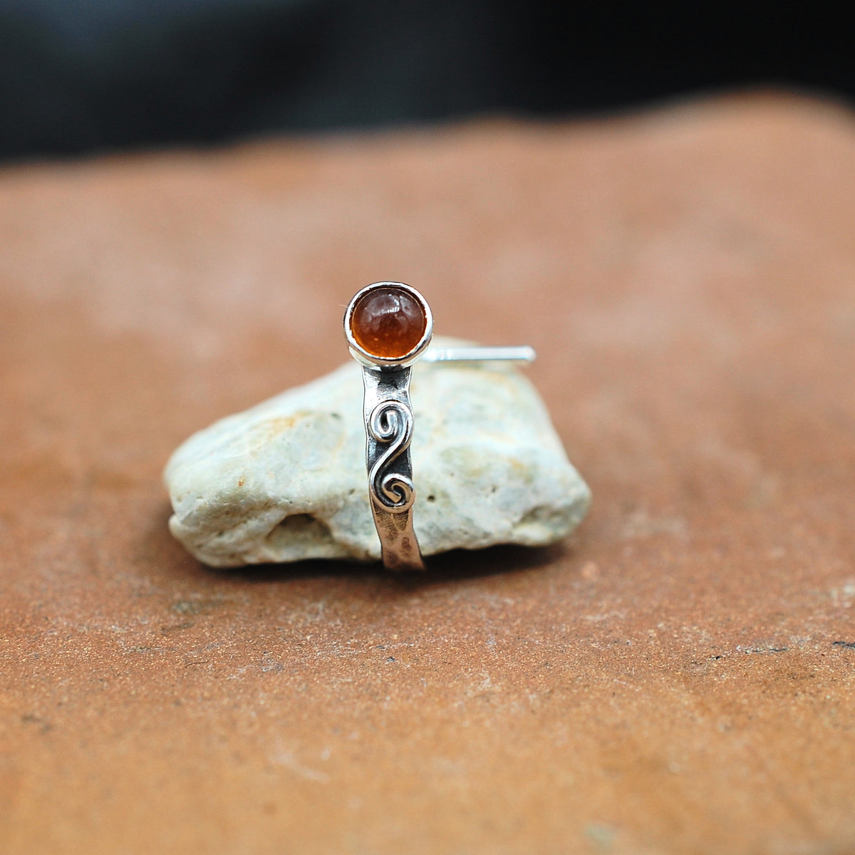 An artisan hammered sterling silver nose cuff is set with a hessonite garnet gemstone and embellished with a hand  twisted swirl.