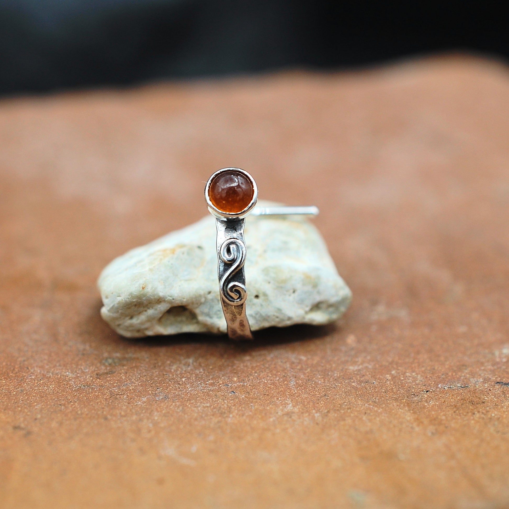 An artisan hammered sterling silver nose cuff is set with a hessonite garnet gemstone and embellished with a hand  twisted swirl.