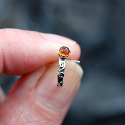 Sterling silver hammered cuff nose ring featuring an orange hessonite garnet gemstone with a hand-twisted metal swirl.