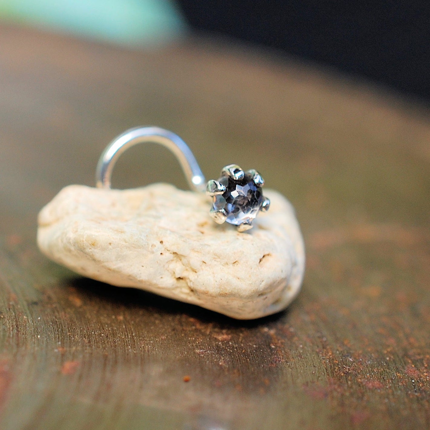 faceted white topaz nose stud on a small rock
