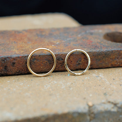 two gold nose rings shown closed - endless rings - hammered and sleek version