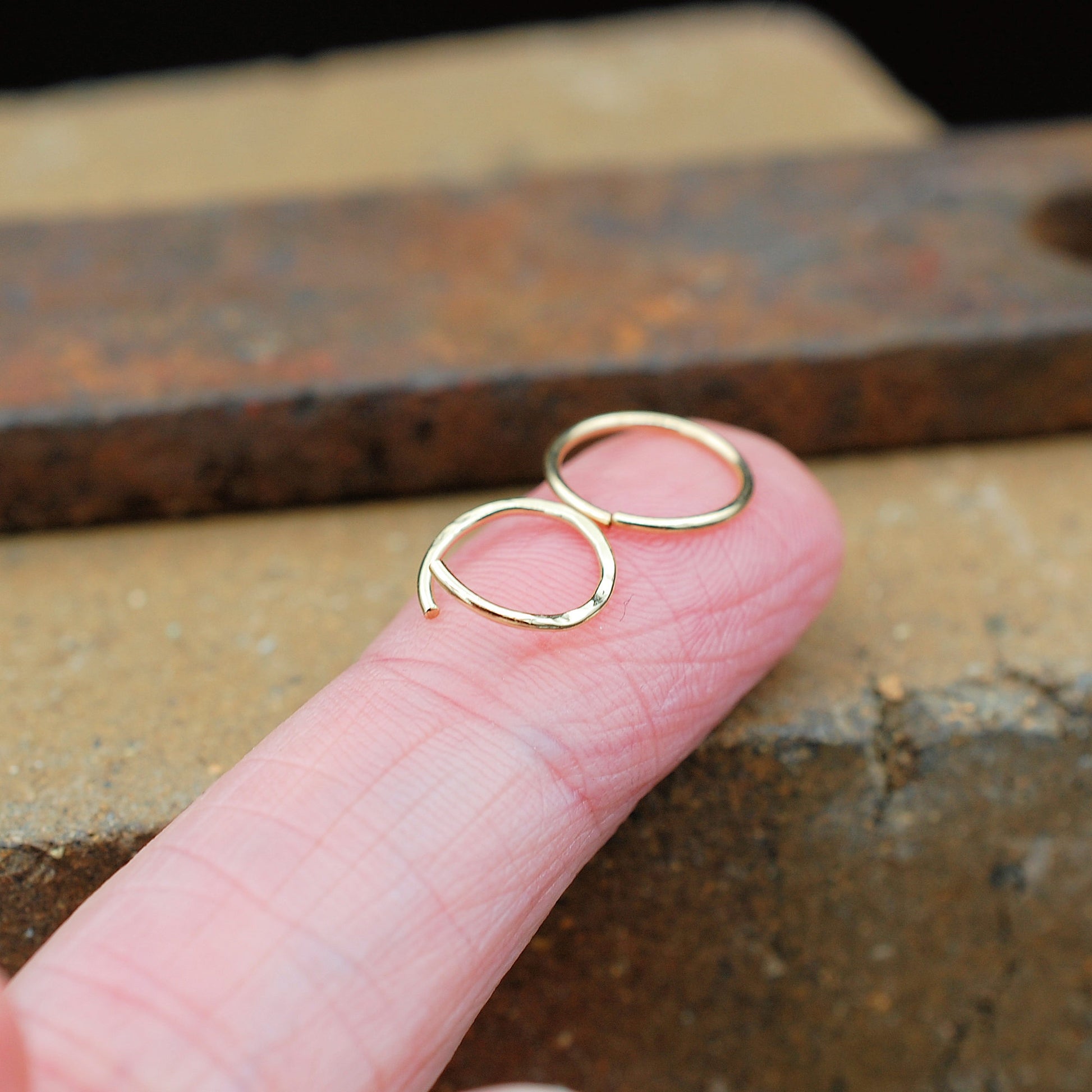 One pair of gold nose rings shown open for insertion