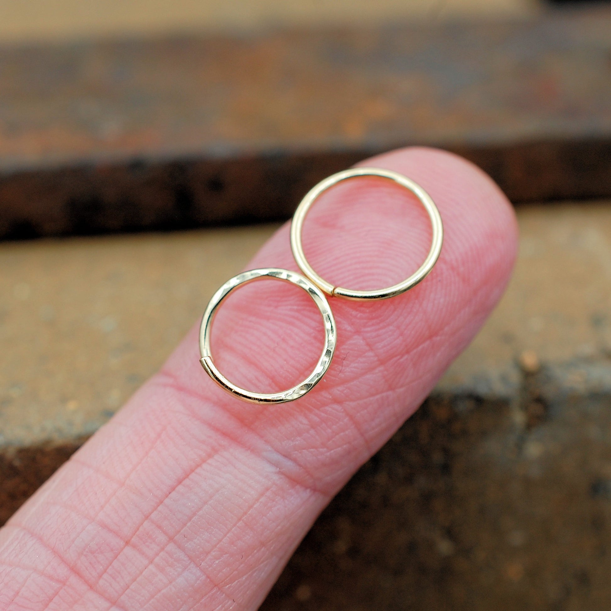 Two endless gold nose rings with hammered pattern and sleek 