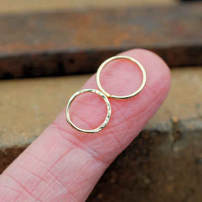 Two endless gold nose rings with hammered pattern and sleek 