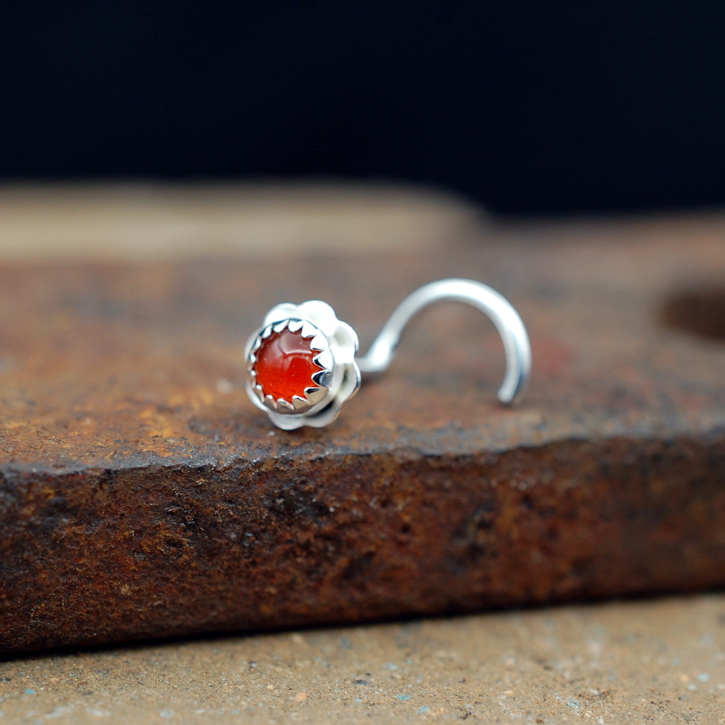 carnelian flower nose stud on a brick
