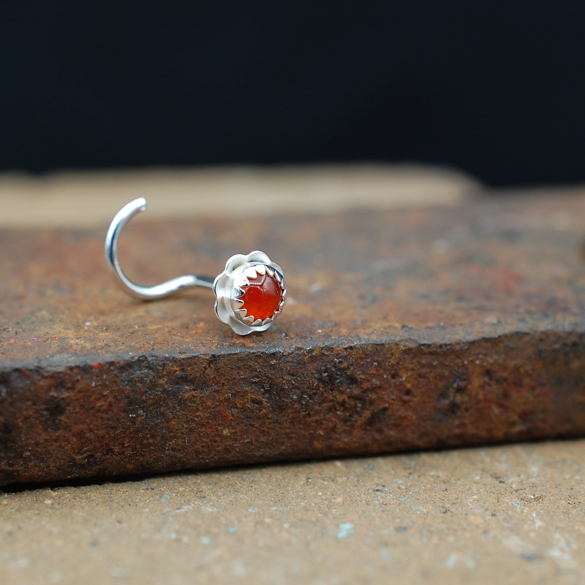 Silver nose stud with orange carnelian stone in a flower setting