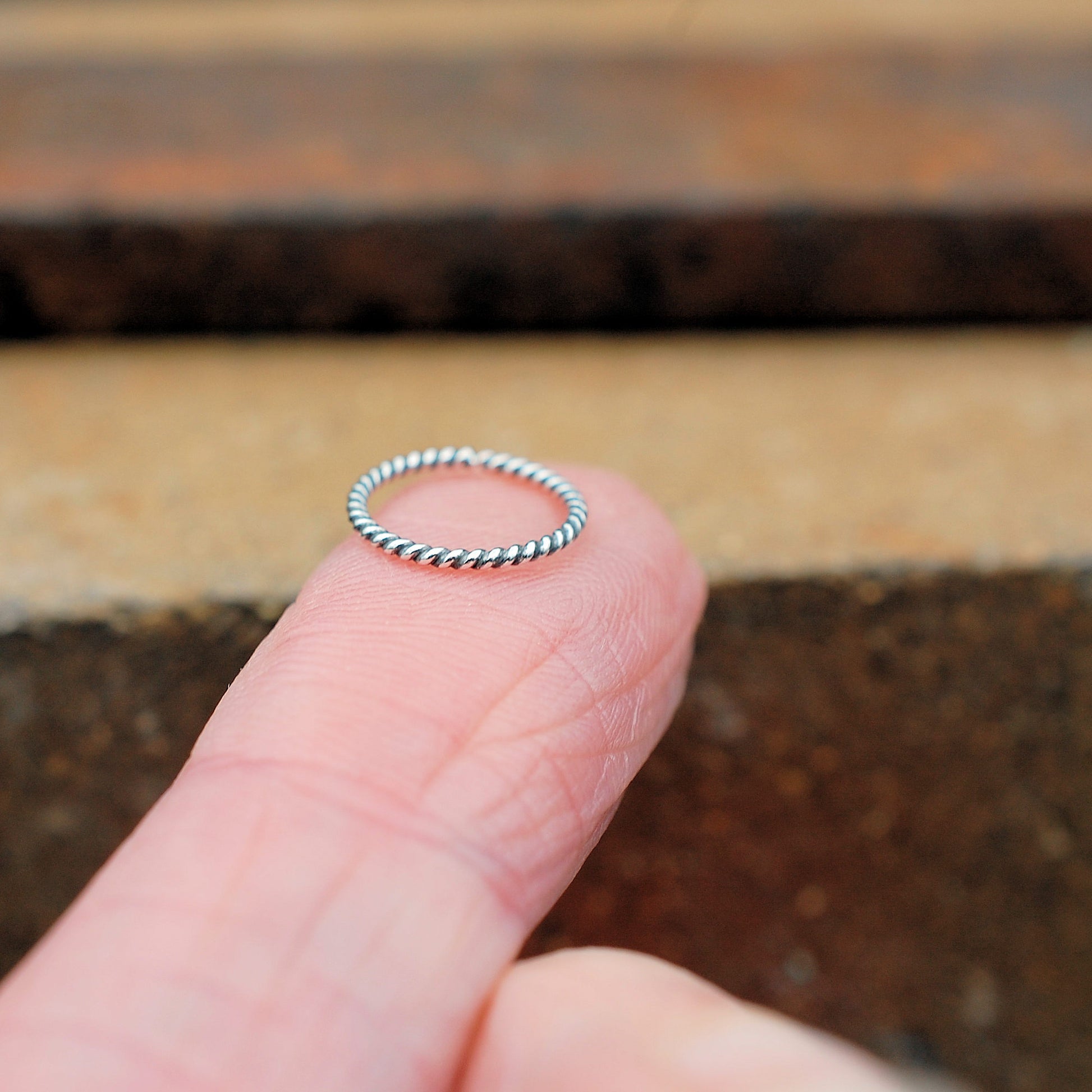 silver nose ring handcrafted to order shown in detail on finger