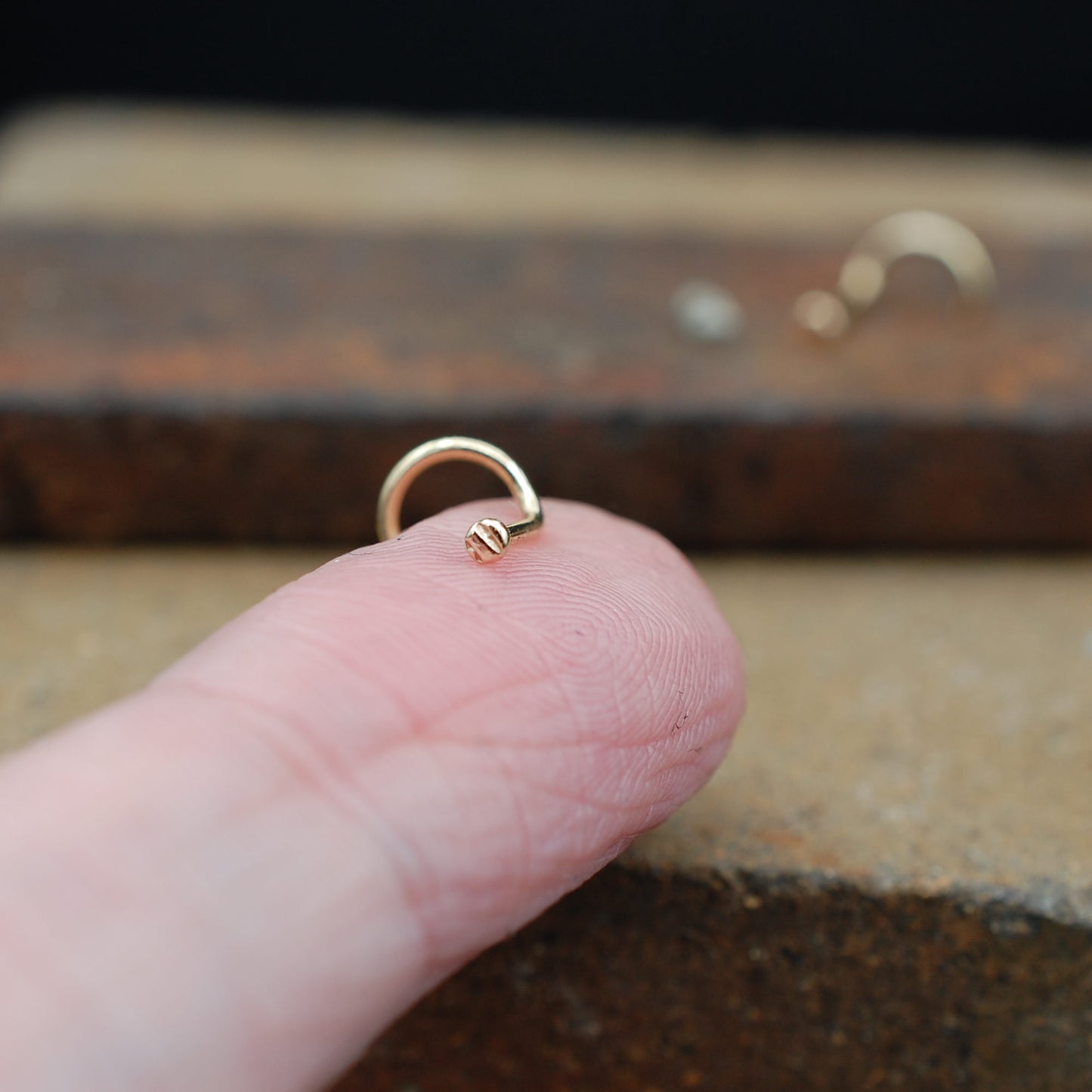 Tiny textured gold disc nose stud 