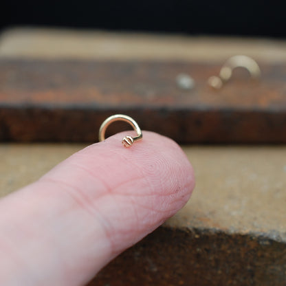 Tiny textured gold disc nose stud 
