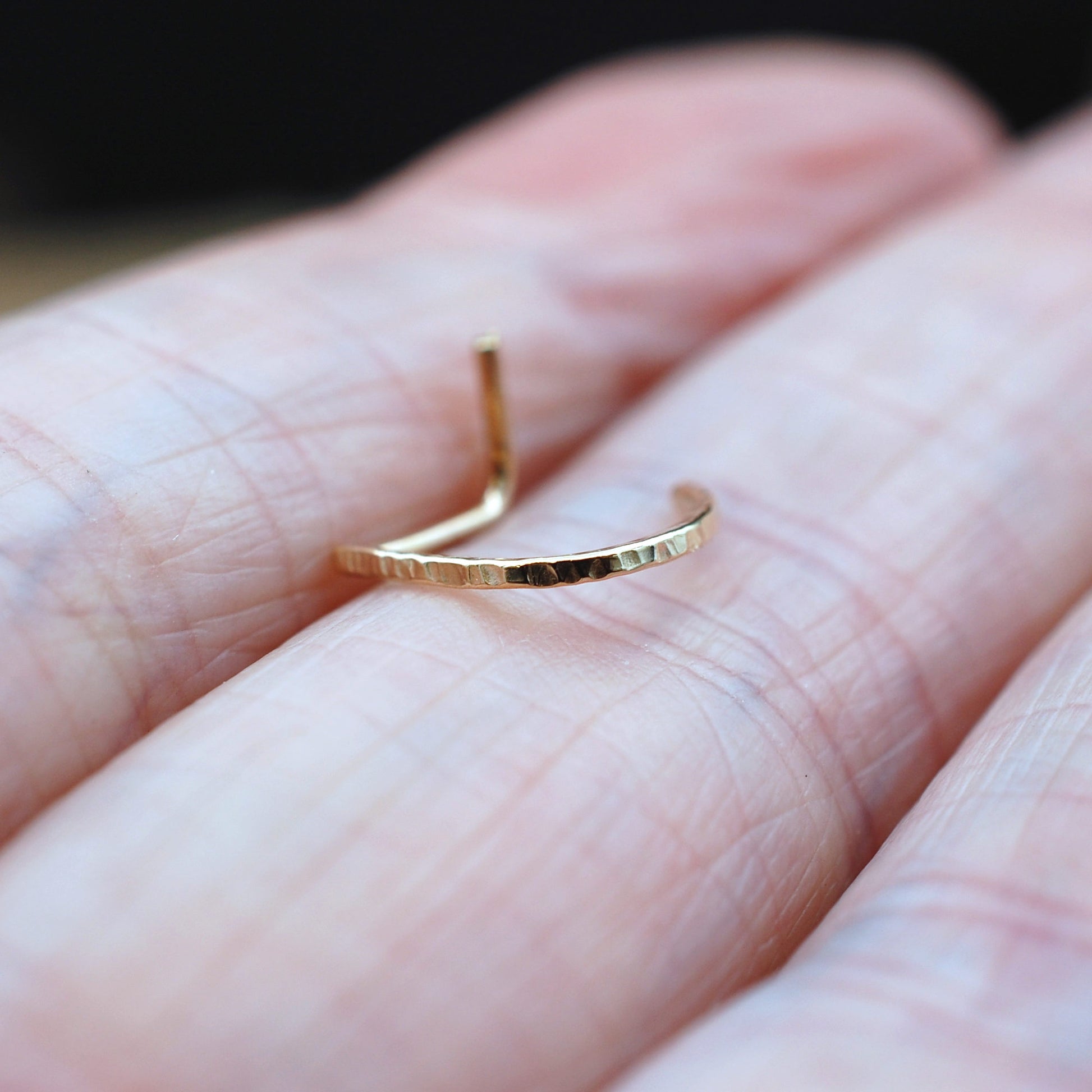 Gold ring on a person's finger with a blurred background