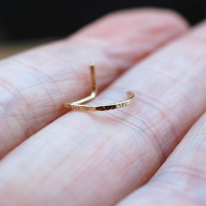 Gold ring on a person's finger with a blurred background
