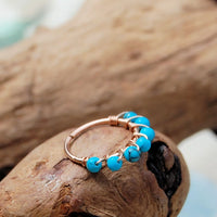 14 karat rose gold nose hoop wrapped with turquoise gemstones